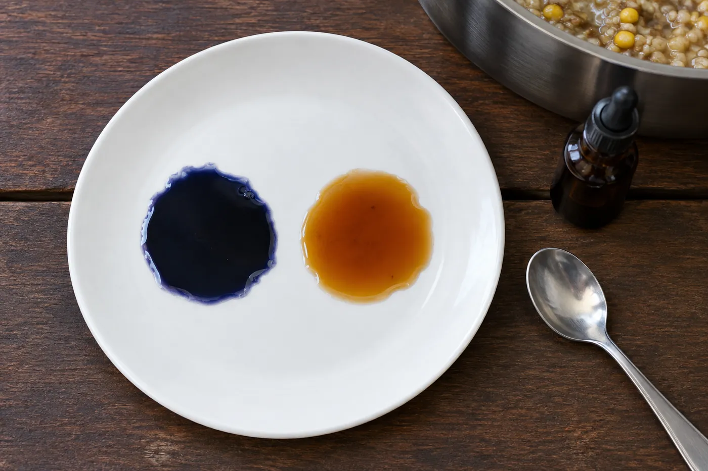 Two puddles of mash liquid on a white plate after a drop of iodine: one blue-black, one amber.